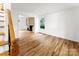 Bright, empty living room featuring hardwood floors, fireplace, and white walls at 9513 Saddle Run Trl, Charlotte, NC 28269