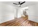Bright, empty living room featuring hardwood floors, white walls, and staircase at 9513 Saddle Run Trl, Charlotte, NC 28269