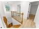 Staircase with wood banister and wrought iron spindles leads to an upper hallway with vinyl flooring at 9513 Saddle Run Trl, Charlotte, NC 28269