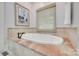 Bathtub with marble surround, tile floors, and a window at 103 3Rd Sw St, Catawba, NC 28609