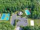 Aerial view of a community clubhouse, pool, tennis courts, and sand volleyball court at 105 Beech Bluff Dr, Mount Holly, NC 28120