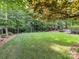 Lush green backyard with mature trees, ideal for outdoor activities and relaxation in a private, serene setting at 105 Beech Bluff Dr, Mount Holly, NC 28120