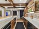 Stylish bar with granite countertops, a sink, wine fridge, and custom wooden cabinets with brick backsplash at 105 Beech Bluff Dr, Mount Holly, NC 28120