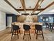 Chic bar area boasts wooden beams, pendant lighting, and a custom bar with seating for entertaining at 105 Beech Bluff Dr, Mount Holly, NC 28120