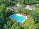 Aerial view of a sparkling community pool surrounded by lush landscaping and lounge chairs at 105 Beech Bluff Dr, Mount Holly, NC 28120
