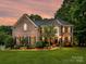 Beautiful two-story brick home with lush landscaping and a well-manicured lawn at 105 Beech Bluff Dr, Mount Holly, NC 28120