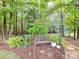 Tranquil garden bench nestled among lush greenery and trees, perfect for relaxation and enjoying nature's beauty at 105 Beech Bluff Dr, Mount Holly, NC 28120