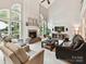 Bright living room with vaulted ceilings, fireplace, and natural light from large windows at 105 Beech Bluff Dr, Mount Holly, NC 28120