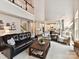 Bright living room featuring soaring ceilings, a dark leather couch, and an open floor plan at 105 Beech Bluff Dr, Mount Holly, NC 28120