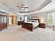 Spacious main bedroom with tray ceilings, carpeted floors, and a walk in closet at 105 Beech Bluff Dr, Mount Holly, NC 28120
