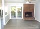Cozy living room with a brick fireplace and sliding glass doors to the outside at 11010 Harrowfield Rd, Charlotte, NC 28226