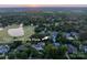 Aerial shot showcases the neighborhood, golf course, and the home with a pool surrounded by lush greenery at 11723 Oakland Hills Pl, Charlotte, NC 28277