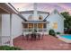 Exterior of the home featuring a patio with outdoor dining set, manicured lawn, and a glimpse of the swimming pool at 11723 Oakland Hills Pl, Charlotte, NC 28277