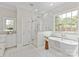 Bright bathroom featuring freestanding tub, glass enclosed shower, and designer tile accents at 11723 Oakland Hills Pl, Charlotte, NC 28277