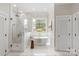 Bright bathroom featuring freestanding tub, glass enclosed shower, and designer tile accents at 11723 Oakland Hills Pl, Charlotte, NC 28277