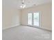 Spacious bedroom boasts a ceiling fan, recessed lighting, and glass French doors opening to a lovely outdoor balcony at 11723 Oakland Hills Pl, Charlotte, NC 28277