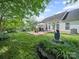 Beautiful backyard with a stone patio featuring outdoor seating and a well-maintained lawn at 11909 Creek Turn Dr, Charlotte, NC 28278