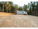 Attractive gray home with white trim, nestled amongst mature trees, offers a serene and private setting at 122 River Ridge Ln, Hickory, NC 28601