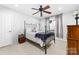 Bedroom with a black wrought iron bed frame, neutral walls, and curtains framing the window at 12712 Hollyhock Ln, Huntersville, NC 28078