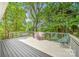 Outdoor deck with chairs, grill, and a view of the surrounding woods at 12712 Hollyhock Ln, Huntersville, NC 28078