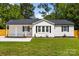 Cozy home featuring freshly painted white exteriors, dark shutters, and a well-maintained green lawn at 1319 Mt Gallant Rd, Rock Hill, SC 29732