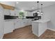 Updated kitchen with white cabinets, sleek black backsplash, and a functional center island with breakfast bar at 1319 Mt Gallant Rd, Rock Hill, SC 29732