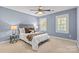Bedroom with blue walls, two windows, ceiling fan, and carpeted floors at 1336 Dobson Dr, Waxhaw, NC 28173