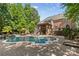 A stunning backyard pool with a stone surround, fireplace, deck, and a covered outdoor bar area is perfect for entertaining at 1336 Dobson Dr, Waxhaw, NC 28173