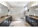 Luxurious bathroom featuring double vanities, a large tiled shower, and neutral tones to create a modern look at 15018 Marymont Ave, Huntersville, NC 28078