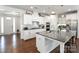 Stylish kitchen boasts white cabinetry, stainless steel appliances, a center island, and hardwood floors at 15018 Marymont Ave, Huntersville, NC 28078