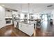 Open kitchen features a large island with seating, stainless steel appliances, and hardwood floors at 15018 Marymont Ave, Huntersville, NC 28078