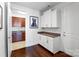 Mudroom with white cabinets, granite countertops and hardwood floors adjacent to the laundry room at 15018 Marymont Ave, Huntersville, NC 28078