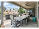 Covered outdoor patio with a large dining table, ceiling fan, and relaxing backyard views at 15018 Marymont Ave, Huntersville, NC 28078