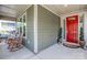 Charming front porch with a vibrant red door and inviting rocking chairs at 15018 Marymont Ave, Huntersville, NC 28078