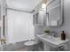 Clean, bright bathroom with a white pedestal sink, mirrored cabinet, and shower with white curtain at 1600 Onslow Dr, Charlotte, NC 28205