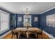 Elegant dining room with dark blue walls, modern chandelier, and large wood table perfect for gatherings at 1600 Onslow Dr, Charlotte, NC 28205