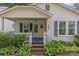 Inviting front porch with a porch swing and detailed trim, enhanced by lush landscaping at 1600 Onslow Dr, Charlotte, NC 28205