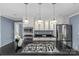 Bright, updated kitchen with stainless steel appliances, a large island with cooktop, and modern lighting at 1600 Onslow Dr, Charlotte, NC 28205