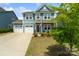 Charming two-story home boasts a two-car garage, manicured lawn, and inviting front porch at 1826 Goodheart Ln, York, SC 29745