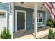 Close-up of a front porch with a dark front door, bench, and American flag at 1826 Goodheart Ln, York, SC 29745