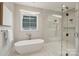 Modern bathroom with a freestanding tub, a glass-enclosed shower, and contemporary fixtures at 213 Crest Ct, Weddington, NC 28104