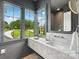 Stylish bathroom offers a marble countertop, modern fixtures, and large windows overlooking a landscaped yard at 213 Crest Ct, Weddington, NC 28104