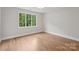 Bright bedroom with hardwood floors and a large window offering views of lush greenery at 213 Crest Ct, Weddington, NC 28104