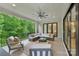 Inviting covered patio with comfortable seating, ceiling fan, black railing, and a beautiful view of the surrounding greenery at 213 Crest Ct, Weddington, NC 28104