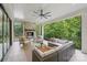 A covered patio features a stone fireplace, ceiling fan, and outdoor seating, perfect for enjoying nature views at 213 Crest Ct, Weddington, NC 28104