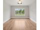 Bright, empty room with hardwood floors and a large window overlooking a beautiful landscape at 213 Crest Ct, Weddington, NC 28104
