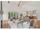 Bright living room boasts high ceilings with wooden beams, neutral furniture, and an open floor plan into the kitchen at 213 Crest Ct, Weddington, NC 28104