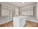 Spacious walk-in closet with custom shelving, a center island, and hardwood floors at 213 Crest Ct, Weddington, NC 28104