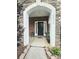 Charming front entrance with black door, stone accents, and potted plants welcoming you home at 2634 Treeline Dr, Concord, NC 28027