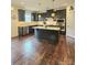 Spacious kitchen offers dark cabinets, an island, stainless steel appliances, and hardwood floors at 2634 Treeline Dr, Concord, NC 28027